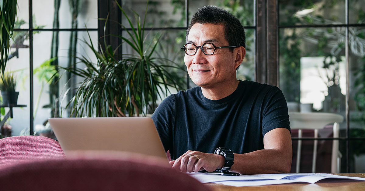 man in glasses working on a laptop