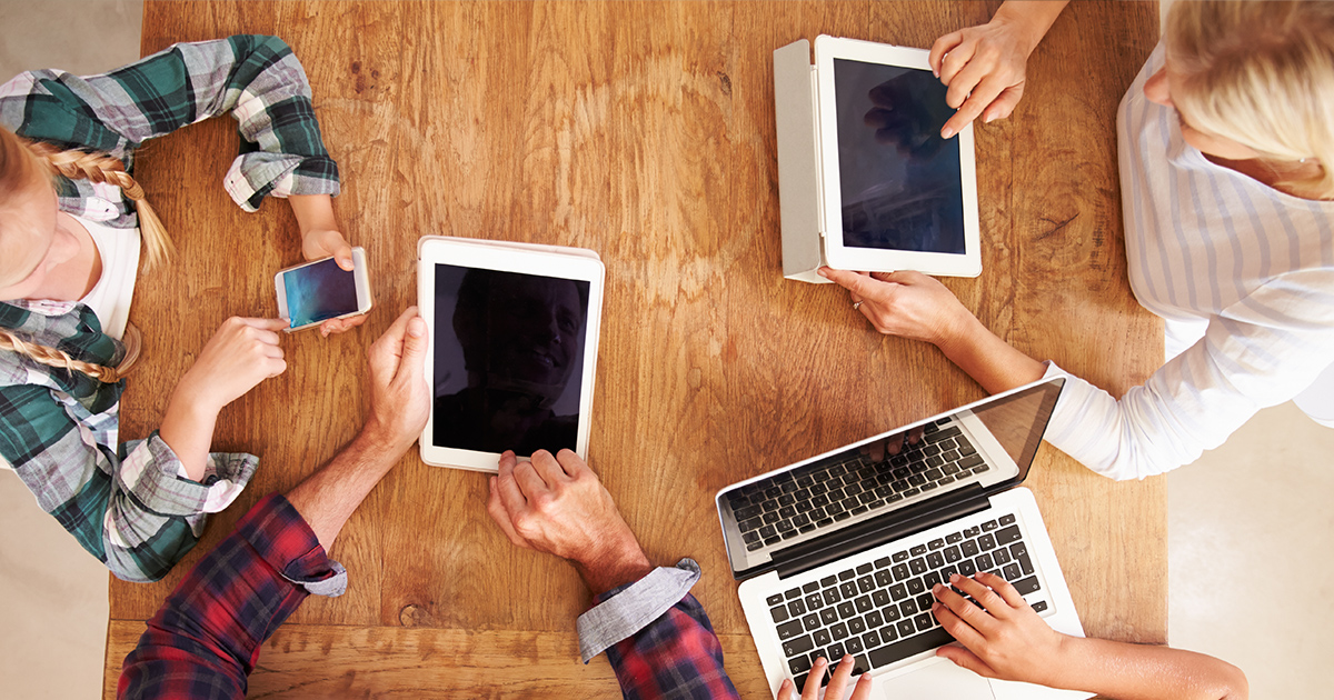 Family around table with devices