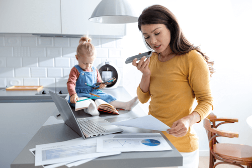 Busy woman working online, taking a phone call, and being a mom