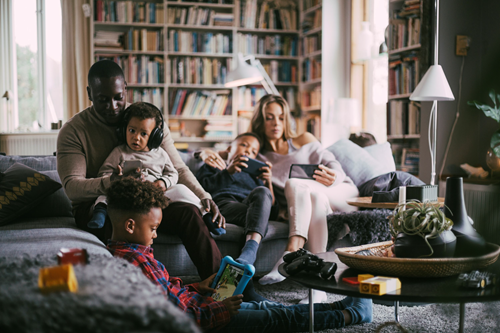 Family lounging in their family room, playing on multiple devices Family lounging in their family room, playing on multiple devices