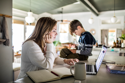 Mom working at home while young son is nearby Mom working at home while young son is nearby