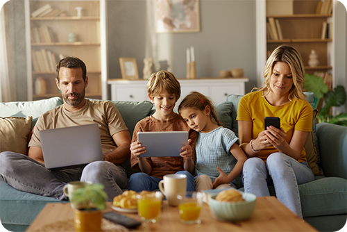 Familia usando Quantum Fiber en sus computadoras portátiles y AT&T Wireless en su dispositivo móvil
