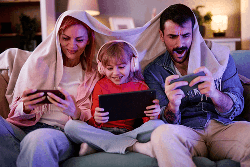 Mom, dad, and child on couch using internet on multiple devices Mom, dad, and child on couch using internet on multiple devices