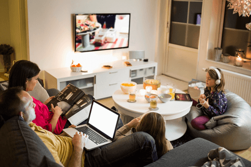 Family gathering together using the internet on multiple devices